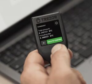 Hand holding Trezor Model T device